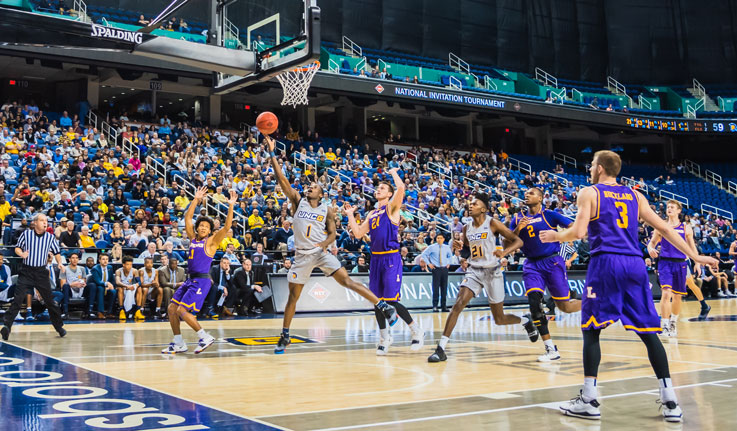 A UNCG basketball player aims for the hoop.