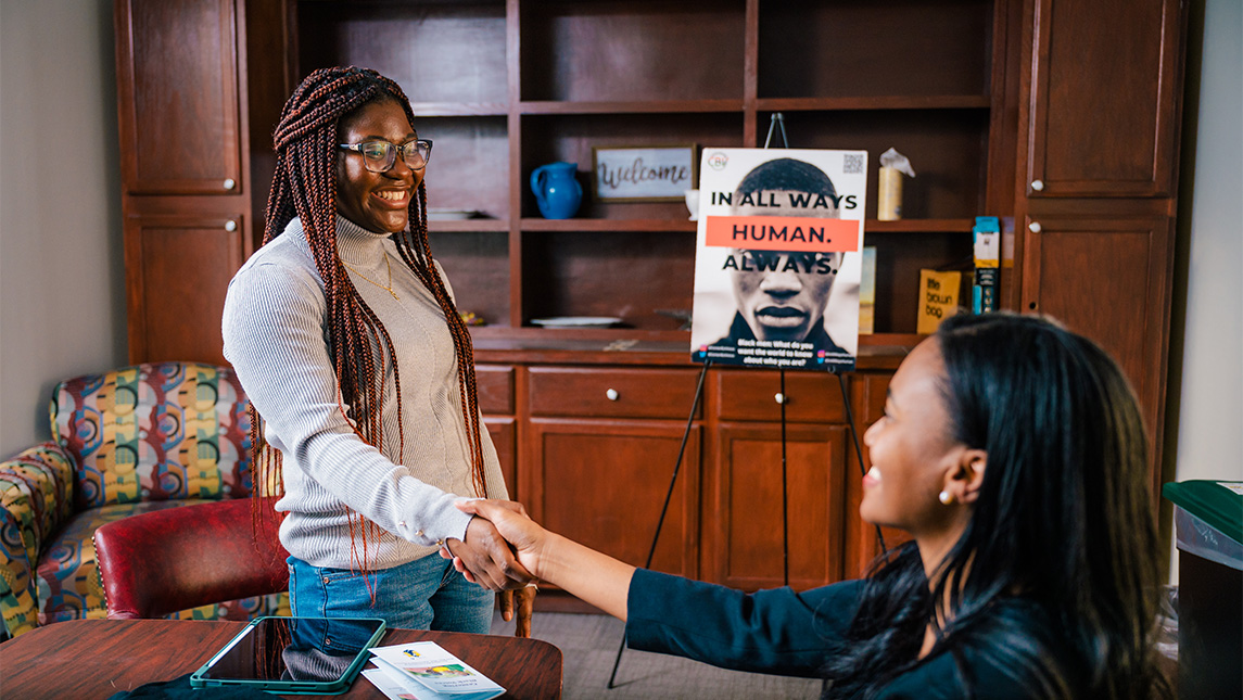 UNCG student Youselene Beauplan shakes hands with Dr. Jocelyn Smith Lee.