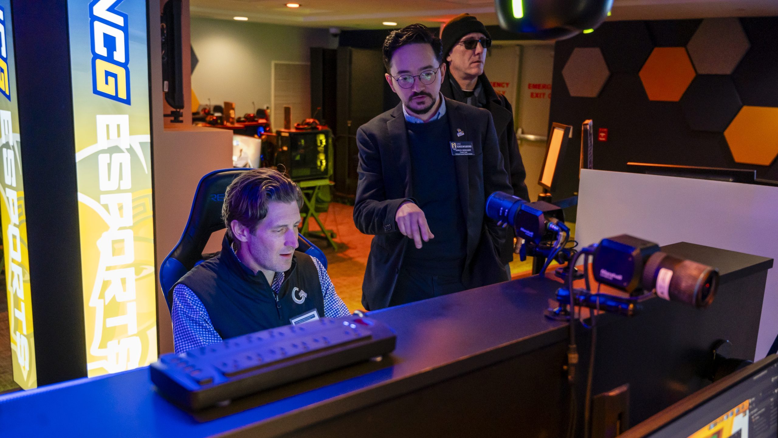 Dr. John Borchert looks on as Joey Cheek tests a video game in the UNCG Esports Arena.