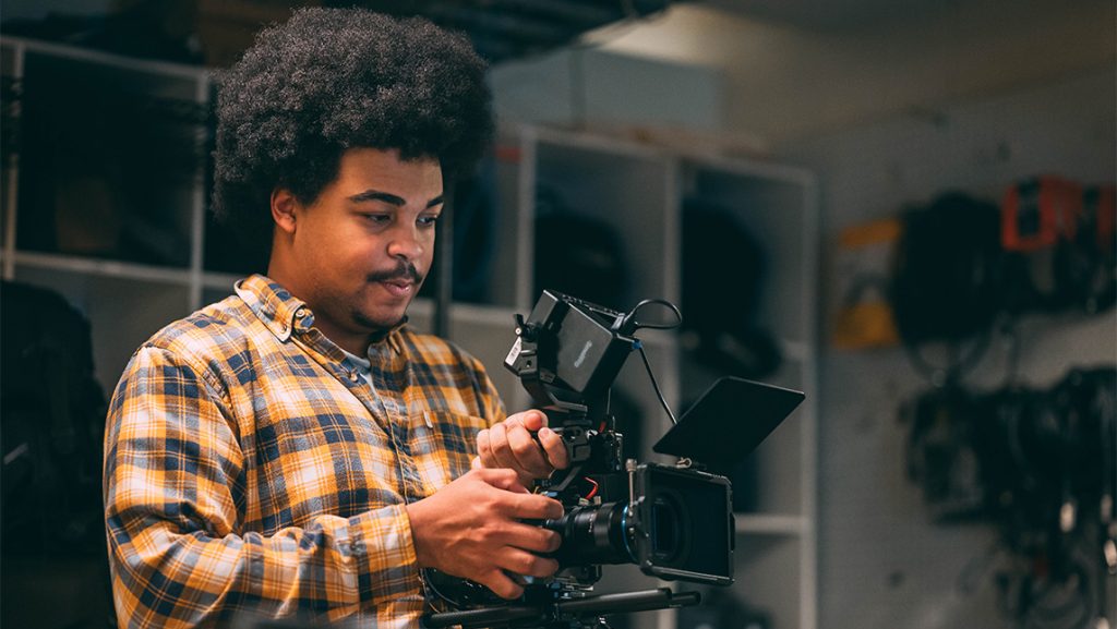 UNCG student Taylee Gaillard looks through the lens of a video camera.