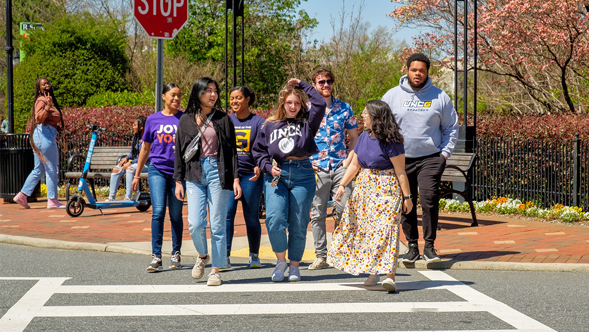 UNCG students cross the street.